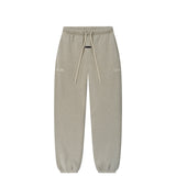 A pair of light gray heather sweatpants with an elastic waistband, matching drawstrings, and subtle tonal text graphics on the upper thighs, shown against a plain white background.