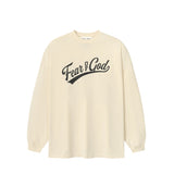 An oversized cream-colored long-sleeve t-shirt with 'Fear & God' printed in black script across the chest, displayed on a clean white background.