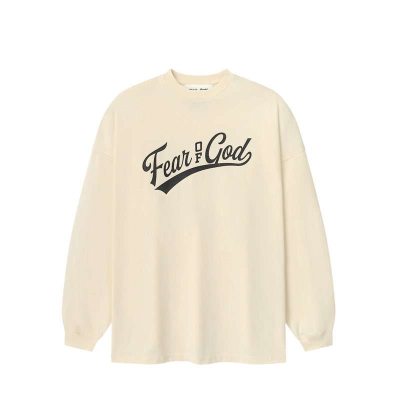 An oversized cream-colored long-sleeve t-shirt with 'Fear & God' printed in black script across the chest, displayed on a clean white background.