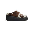 Brown and white cow print clog shoe on a white background