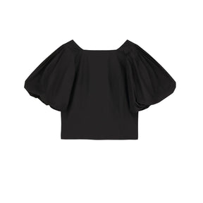 Black off-shoulder top on a white background